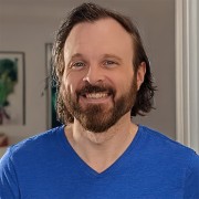 Smiling man with dark hair and facial hair